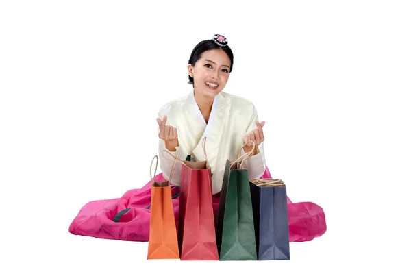 身穿韩国传统民族服装的亚洲女人汉博克坐在那里 展示着白色背景的购物袋 — 图库照片