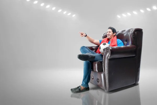 Азиатский Мужчина Шарфом Мячом Сидит Диване Смотрит Футбол Телевизору — стоковое фото