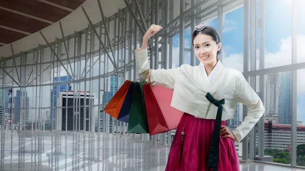 身穿韩国传统民族服装的亚洲女人汉博克站在购物中心 手里拿着购物袋 — 图库照片