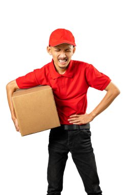 Beyaz arka planda izole edilmiş bir paket taşıyan şapkalı bir teslimatçı karın ağrısı hisseder.