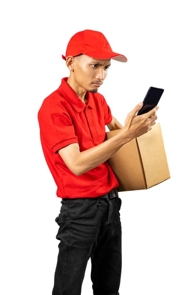 带着帽子拿着手机 背着白色背景包裹的包裹递送员 — 图库照片