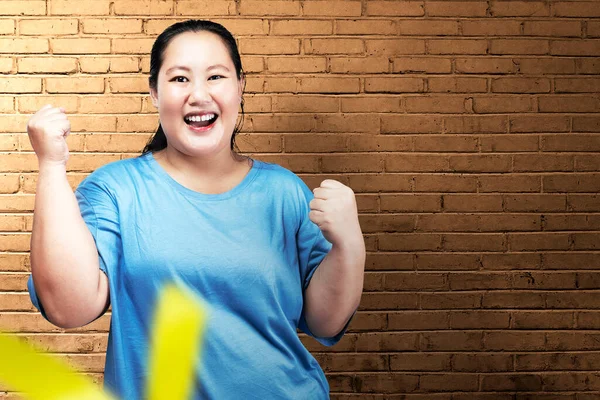 亚洲胖女人 有兴奋的表情 有砖墙背景 — 图库照片