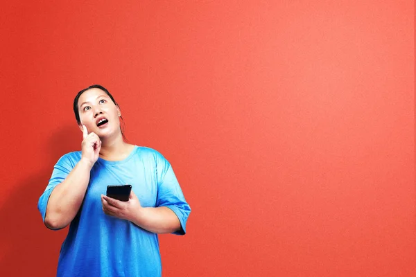 Азиатская Толстая Толстая Женщина Держит Мобильный Телефон Думая Цветным Фоном — стоковое фото