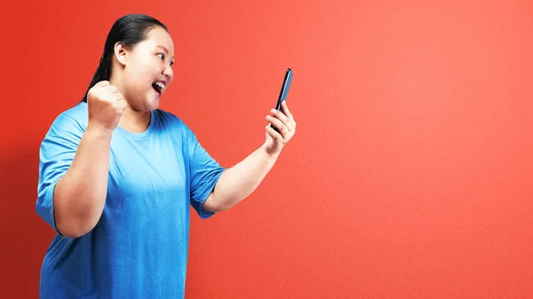 Asyalı Şişman Şişman Kadın Elinde Renkli Arka Planda Heyecanlı Bir — Stok fotoğraf