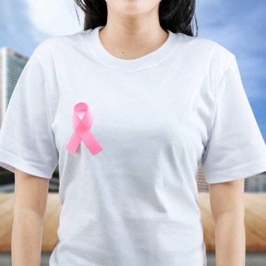 Beyaz gömlekli bir kadın mor bir kurdele gösteriyor. Dünya Kanser Günü