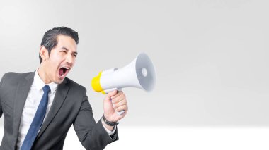 Asyalı işadamı renkli bir arka planda megafonla bağırıyor.