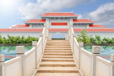 Kırmızı çatılı Çin pavyonu kapısı ve mavi arkaplanlı kemer köprüsü.