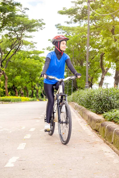 公園でヘルメット自転車に乗るアジアの女性 — ストック写真