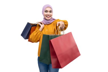 Asian Muslim woman in a headscarf holding shopping bags isolated over white background