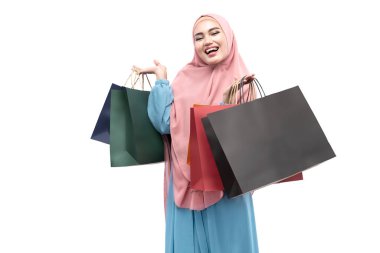 Asian Muslim woman in veil holding shopping bags isolated over white background