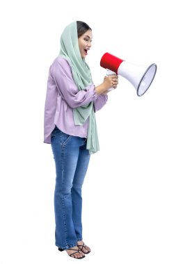 Asian Muslim woman in a headscarf yelling on a megaphone isolated over white background