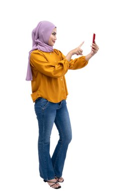 Asian Muslim woman in a headscarf using a mobile phone isolated over white background