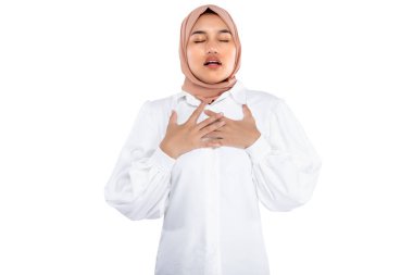 Asian Muslim woman in a head scarf feeling chest pain isolated over white background