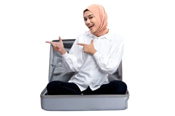 Asian Muslim Woman Headscarf Sitting Suitcase Pointing Something Isolated White — Stok fotoğraf