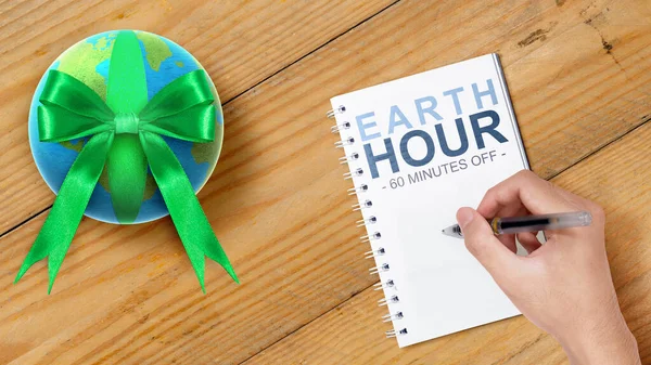 Human Hand Write Something Notebook Earth Hour Concept — стоковое фото