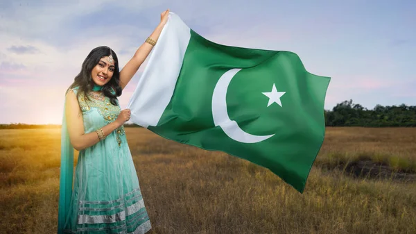 Asian woman holding Pakistan flag. Pakistan Resolution Day