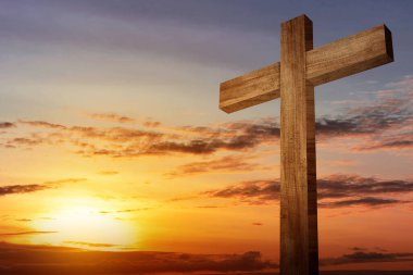 Christian Cross on the field with sunset sky background