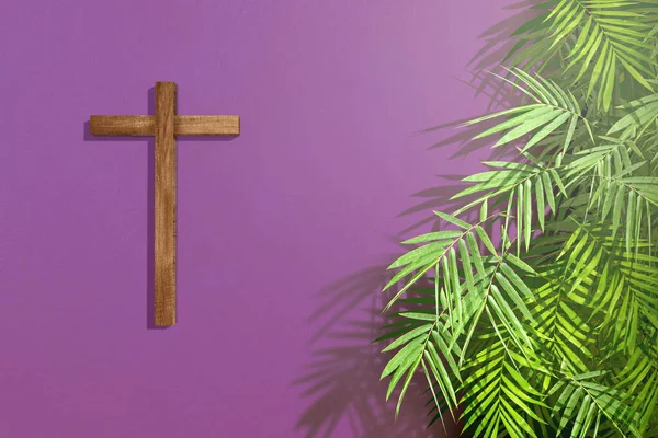 Cross and palm leaf on a colored background. Palm Sunday Concept