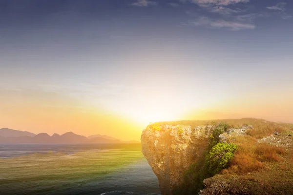 Edge of a cliff with ocean view and sunset sky background