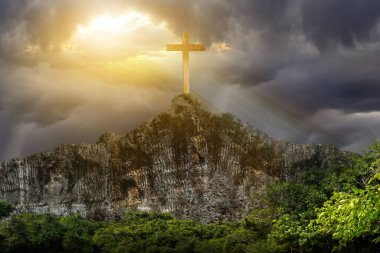 Christian Cross on the rock hill with dramatic sky background