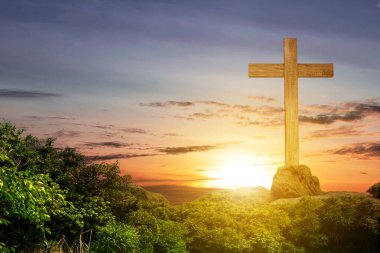 Christian Cross on the rock hill with sunset sky background
