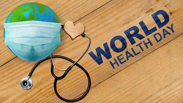 Earth with face mask and stethoscope with heart. World Health Day Concept