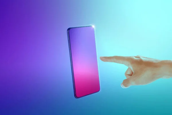 Human hand pointing mobile phone screen on a colored background