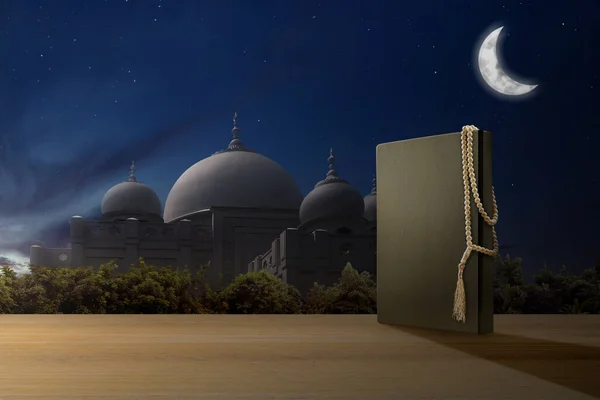 古兰经 和祈祷珠在木制桌子上 旁边有一座清真寺 背景是夜景 — 图库照片
