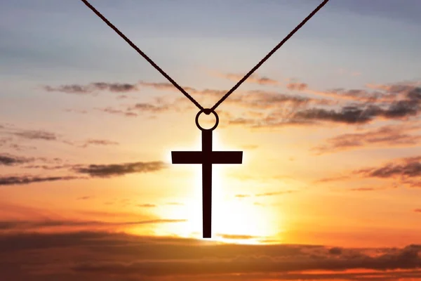 Christian Cross with sunset sky background