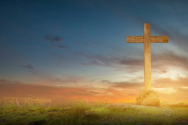 Christian Cross on the field with sunset sky background