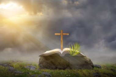 Çapraz ve günbatımı sahne arkaplanlı açık kitap ve palmiye yaprağı. Palm Sunday Konsepti