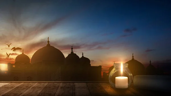 古兰经 和蜡烛在木制桌子上 夕阳西下的背景是一座清真寺 — 图库照片