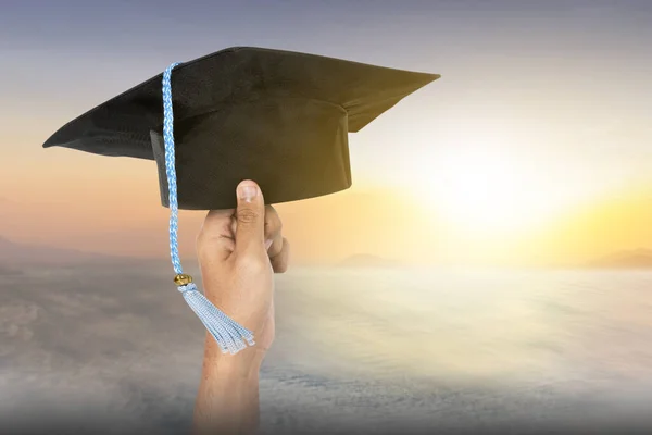 Absolventen Studenten Halten Abschlussmützen Mit Dem Hintergrund Des Sonnenuntergangs — Stockfoto