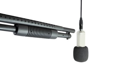 Asılan mikrofonu hedef alan silah beyaz arkaplanda izole edilmiş.