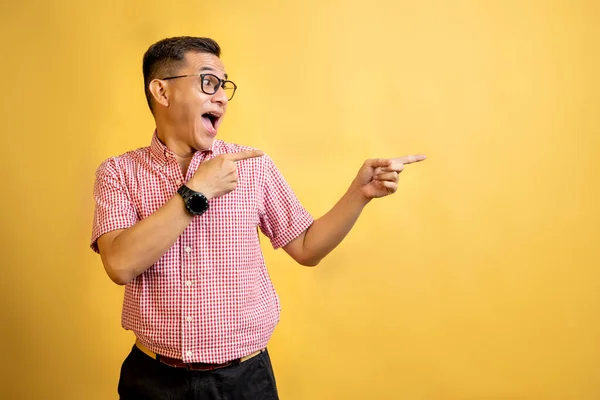 Mann Mit Brille Und Hemd Zeigt Auf Etwas Auf Farbigem — Stockfoto