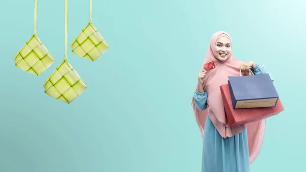 アジアのイスラム教徒の女性でベール保持クレジットカードとショッピングバッグで色の背景 — ストック写真