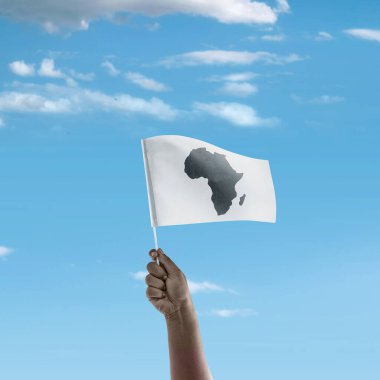 Mavi gökyüzü arkaplanlı Afrika haritalı bir bayrağı tutan bir insan eli. Afrika günü konsepti