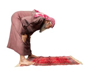 Muslim man with a beard wearing keffiyeh with agal in praying position (salat) on the prayer rug isolated over white background clipart