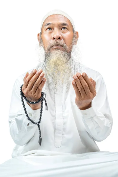 穆斯林男子 留着胡子 头戴白帽 手上拿着祈祷珠子 孤零零地坐在白色的背景上祈祷 — 图库照片
