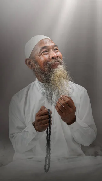 Muszlim Férfi Szakállal Fehér Sapkában Imádkozik Imagyöngyökkel Kezén Világos Háttérrel — Stock Fotó