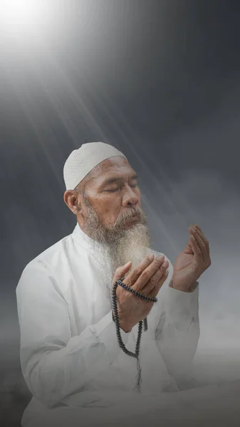 Мусульманин Бородой Белой Кепке Молится Четками Руках Ярком Светлом Фоне — стоковое фото