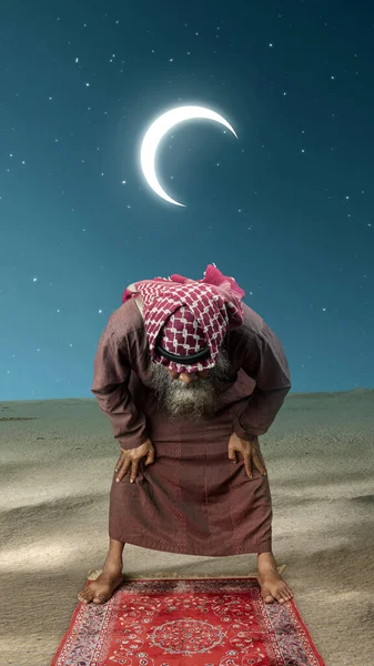 夜の風景を背景に 祈りの敷物の上で祈りの位置 サラート でAgalとKefiyehを身に着けている髭を持つイスラム教徒の男 — ストック写真