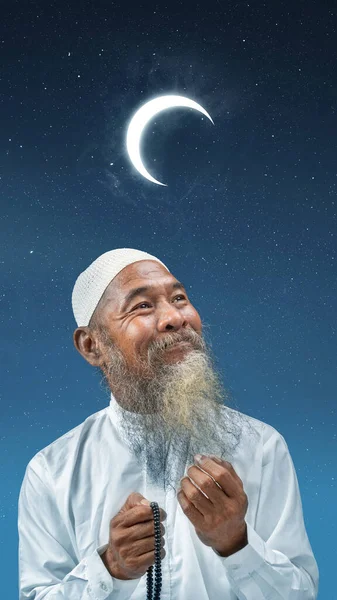 穆斯林男子 留着胡须 头戴白帽 手上拿着祈祷珠子 背景是夜景 — 图库照片