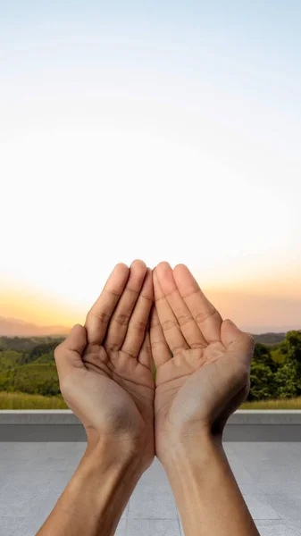 Muslim man raised hands and prayed with sunlight background