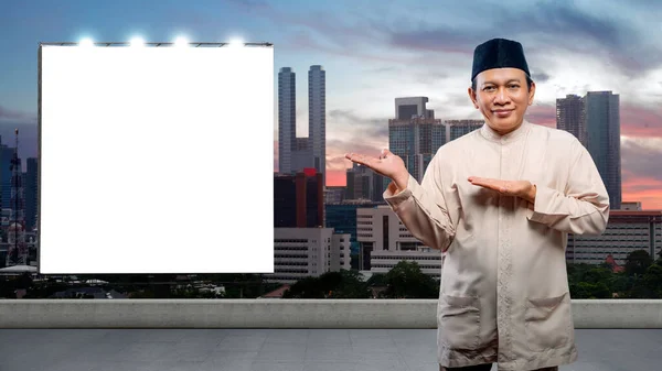 亚洲穆斯林男子张开手掌 在城里展示一块空广告牌 — 图库照片