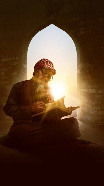 髭を生やしたイスラム教徒の男は モスク内の礼拝用の敷物の上に座ってクルアーンを読みます — ストック写真