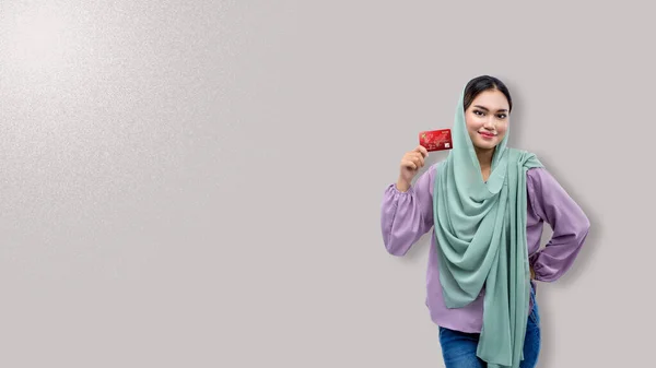 Asiatische Muslimin Mit Kopftuch Hält Eine Kreditkarte Auf Farbigem Hintergrund — Stockfoto