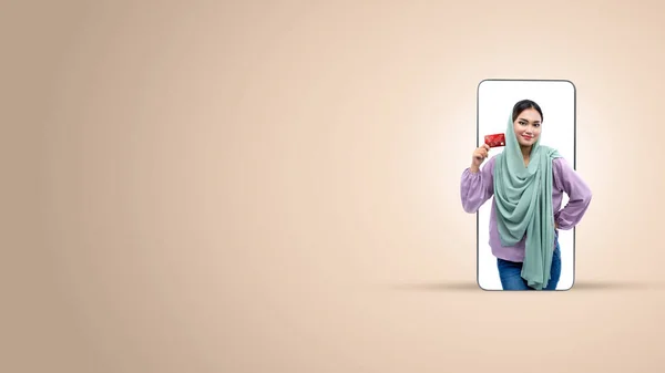 Azjatycka Muzułmanka Chustce Trzymająca Kartę Kredytową Ekranie Telefonu Komórkowego Kolorowym — Zdjęcie stockowe