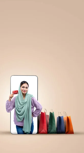 Азиатская Мусульманка Платке Держащая Кредитку Экране Мобильного Телефона Цветным Фоном — стоковое фото