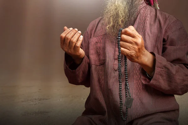 穆斯林男子 留着胡子 头戴头巾 双手拿着祈祷珠子 背景引人注目 — 图库照片